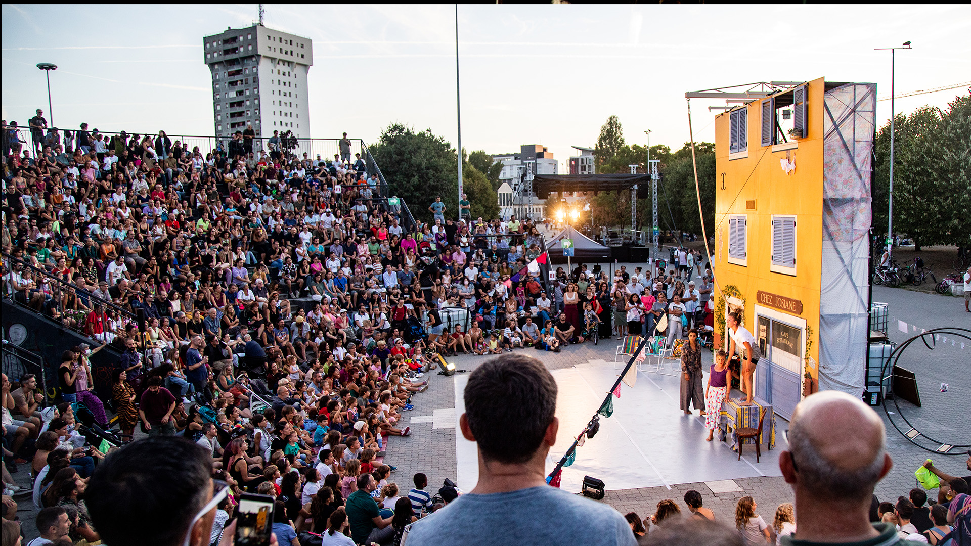 Il pubblico sulle gradinate stracolme assiste allo spettacolo di teatro.