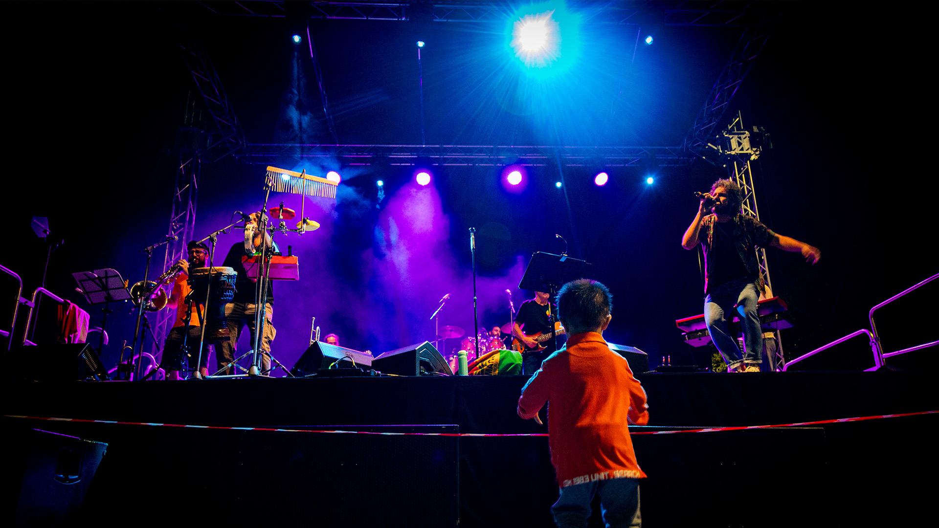 Un bambino in prima fila assiste a un concerto.